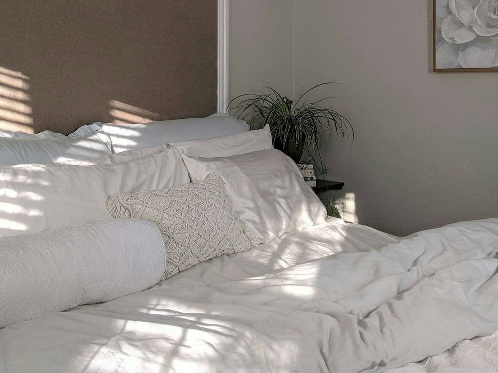 Quarto com cama arrumada e luz natural